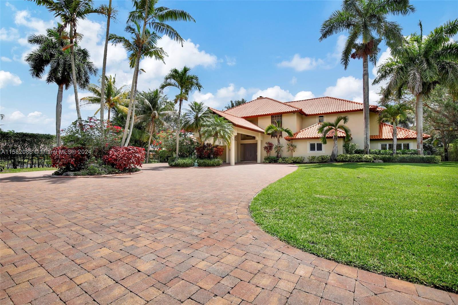 a view of a house with a yard and coconut trees