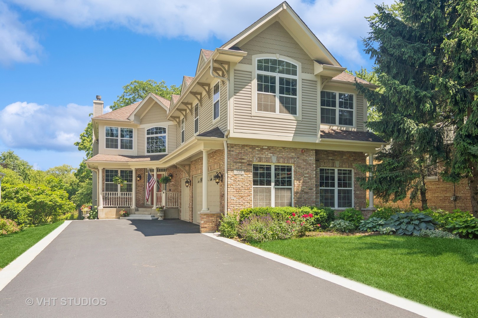 a front view of a house with a yard and trees