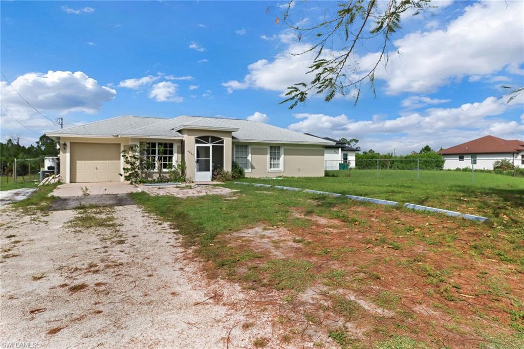 Single story home with a front yard and a garage