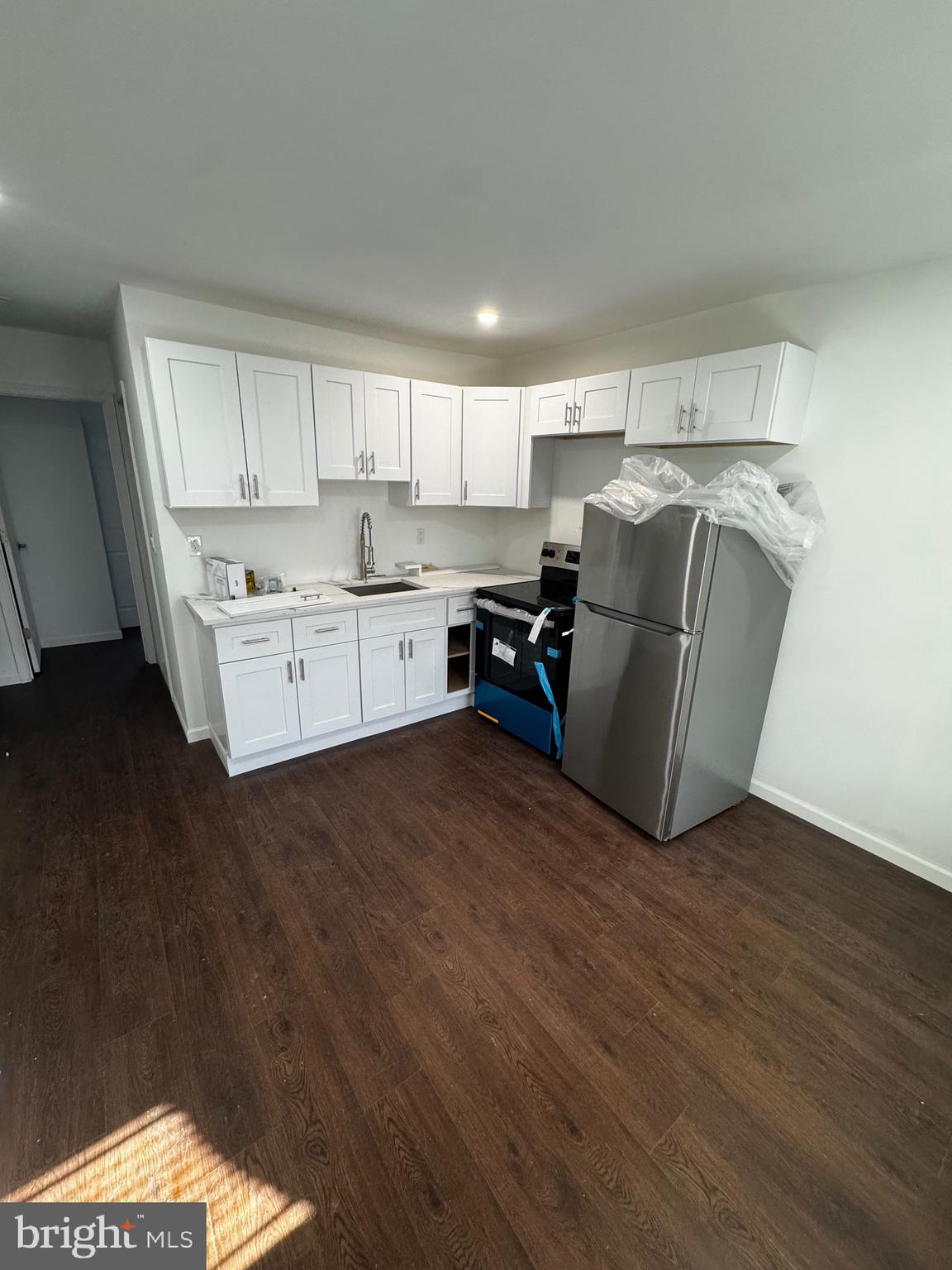 a kitchen with cabinets and wooden floor