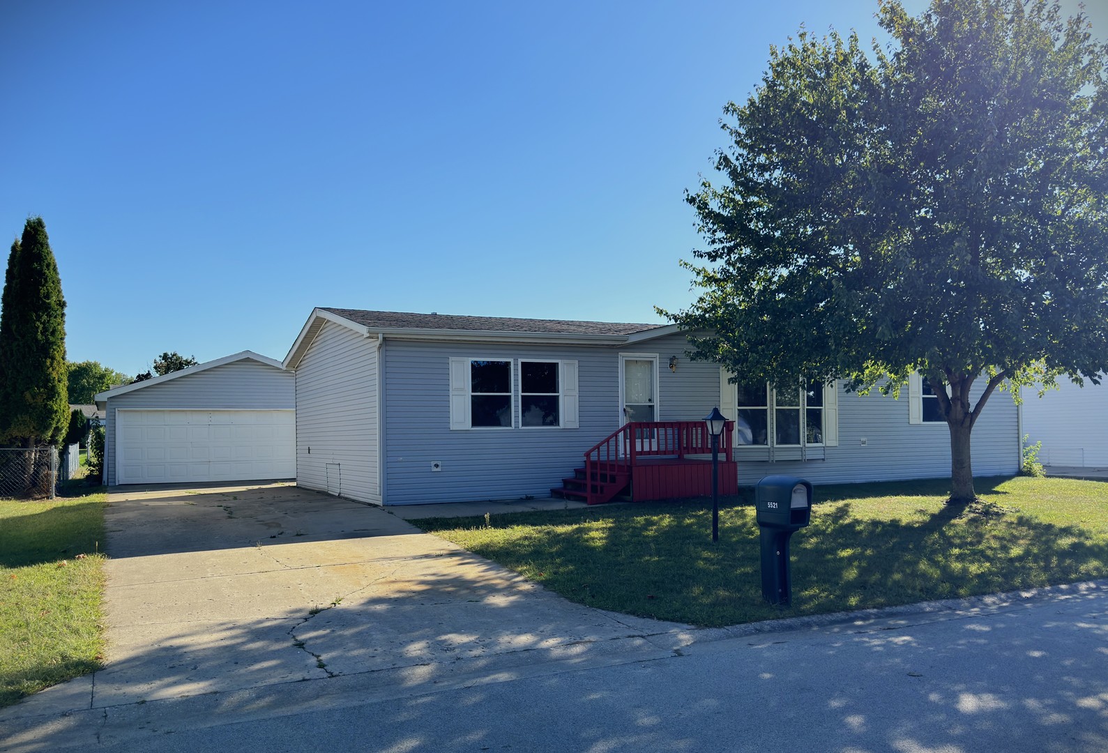 a front view of a house with a yard and tree