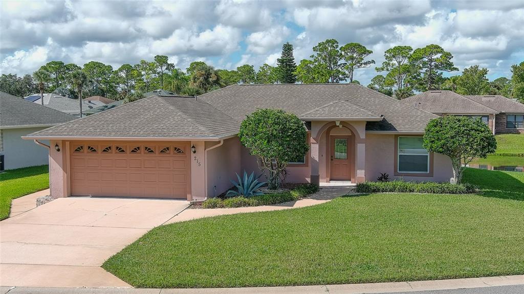 a front view of a house with a yard and garage