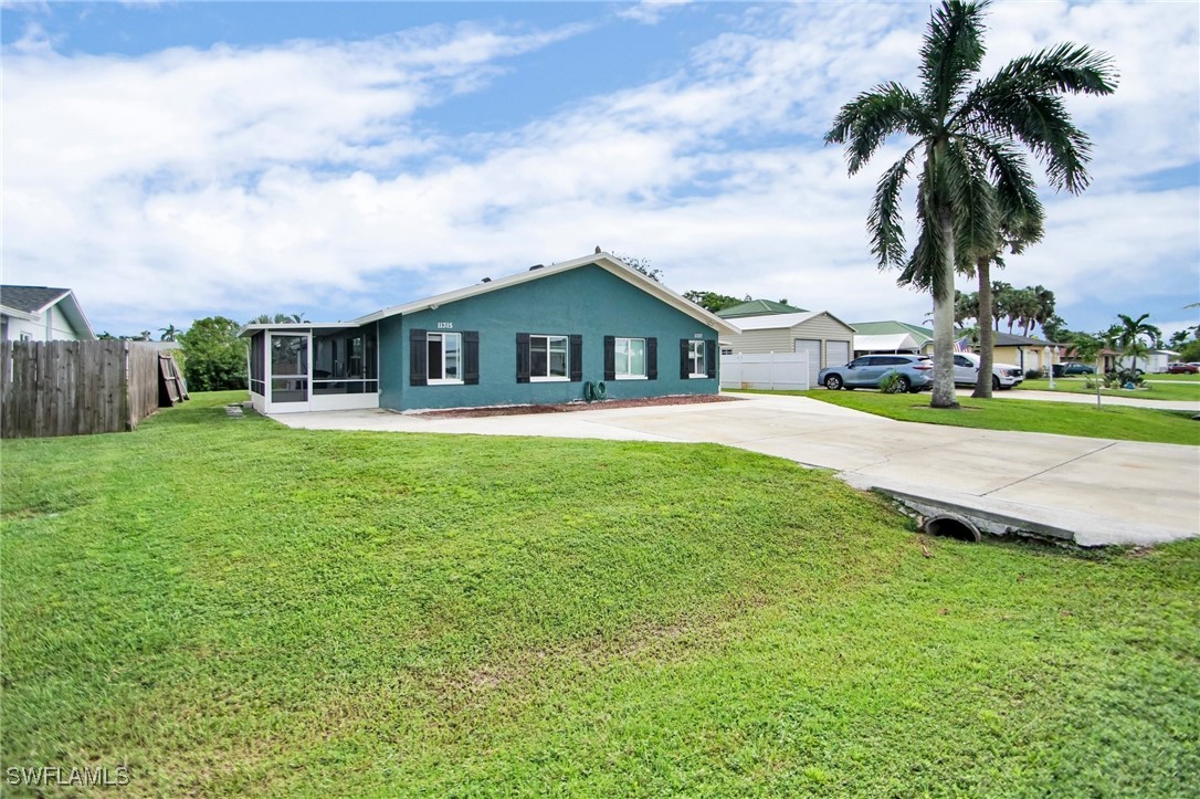 a view of a house with a big yard and palm trees