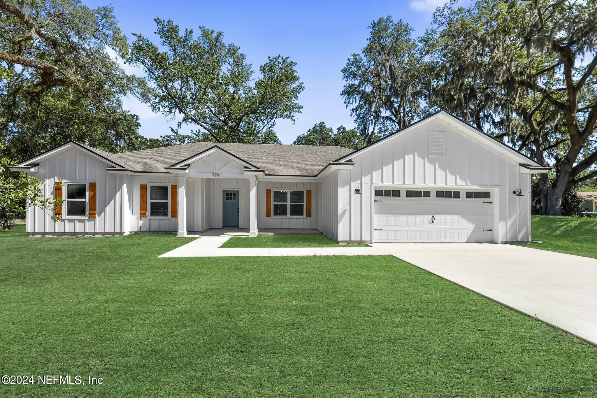 a front view of a house with a garden and yard