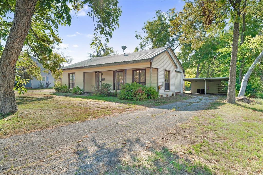 a front view of a house with a yard and trees