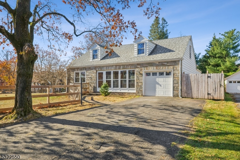 a view of a house with a large tree and wooden fence