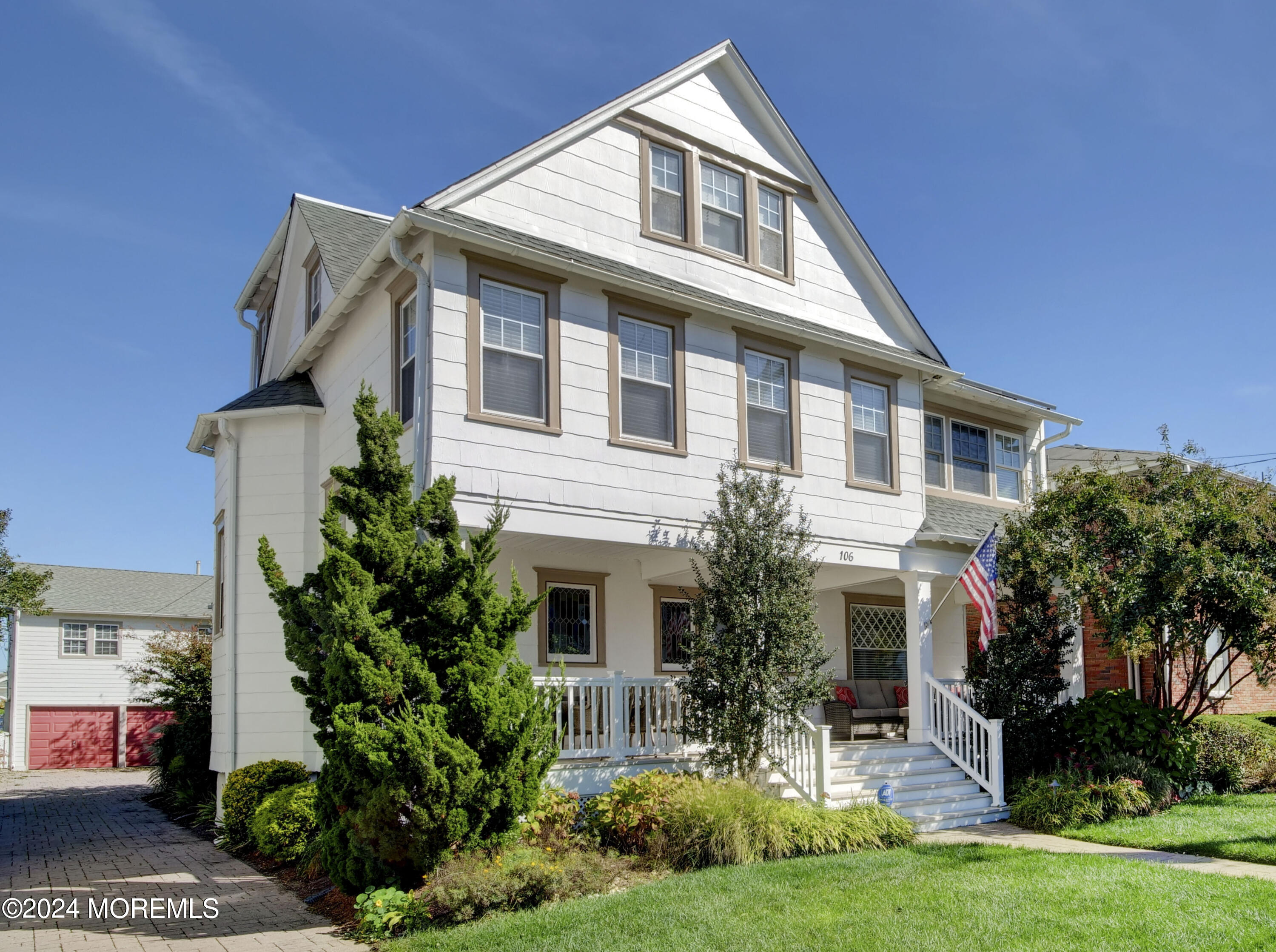 a front view of a house with a yard and potted plants