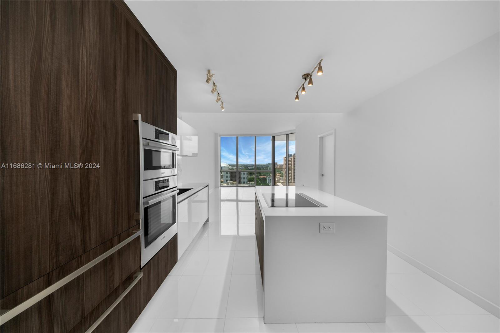 a kitchen with kitchen island a counter top space a sink stainless steel appliances and cabinets