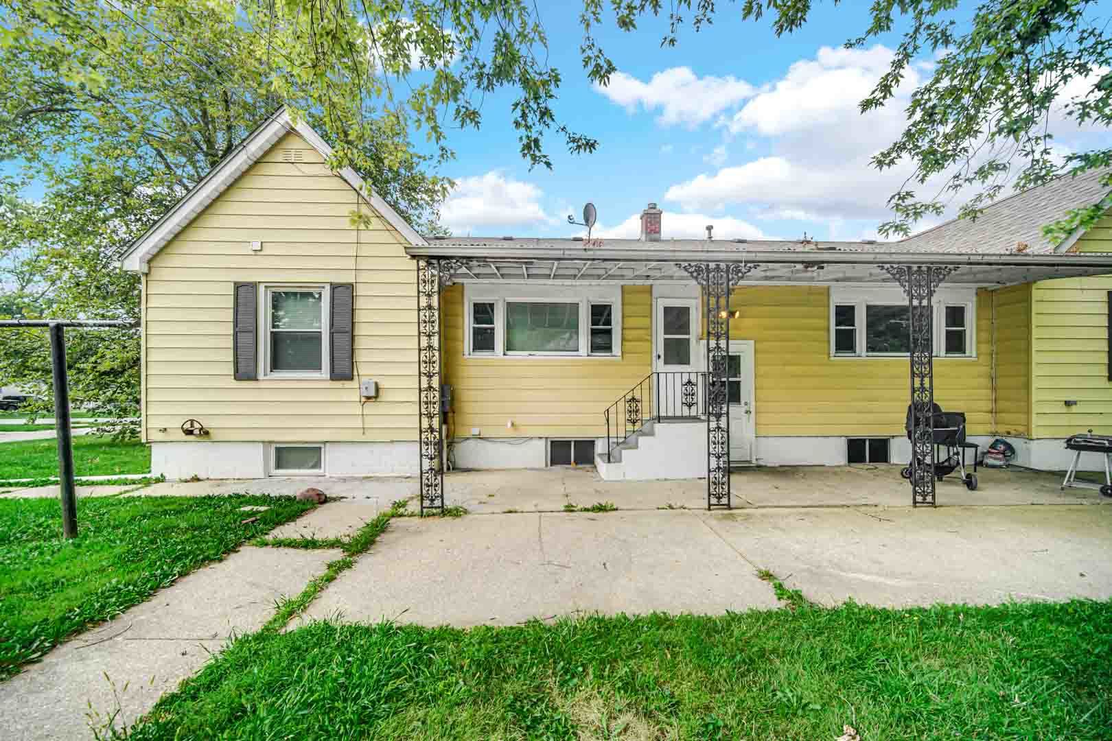 a front view of a house with a yard and outdoor seating