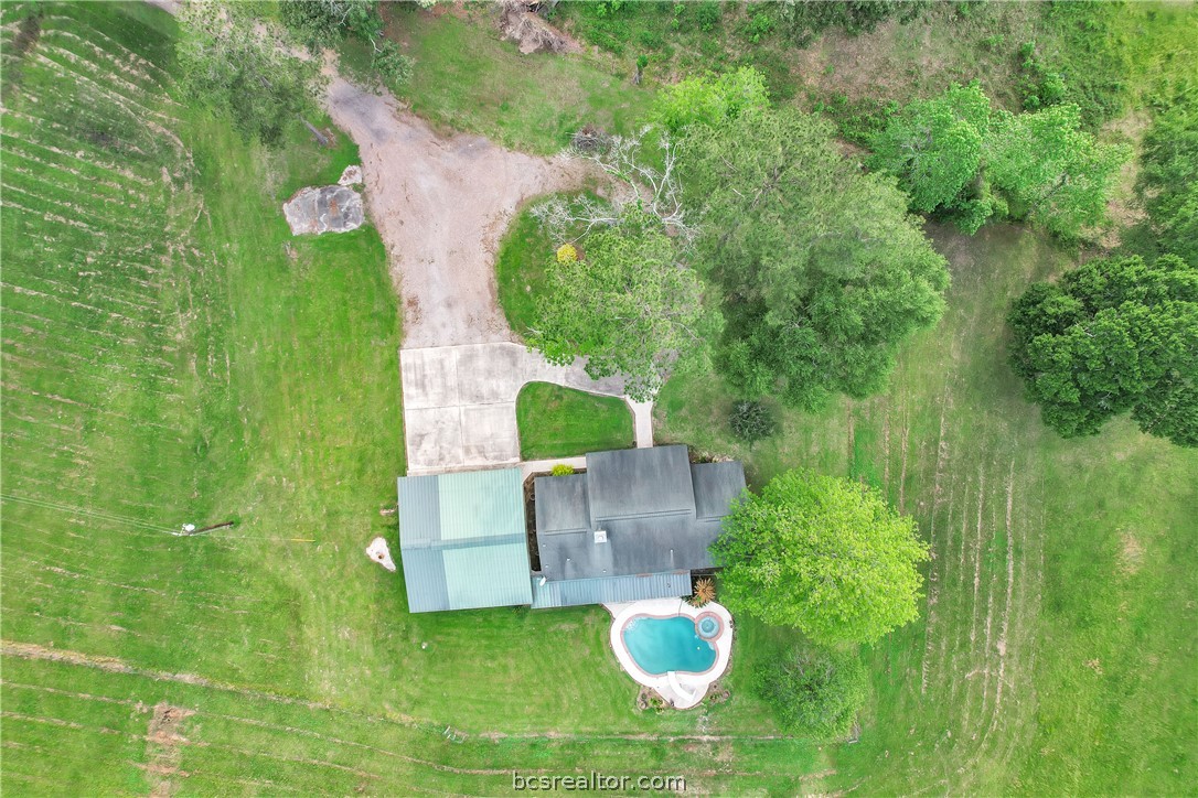 an aerial view of a house with pool yard outdoor and green space