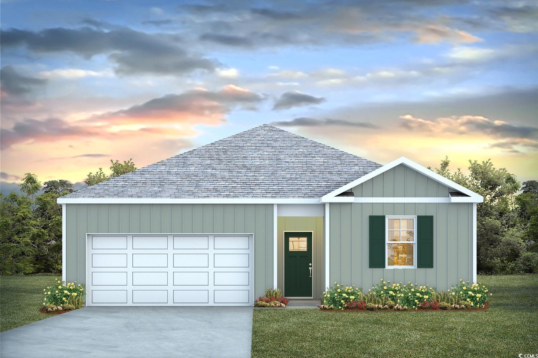 View of front facade featuring a garage and a yard