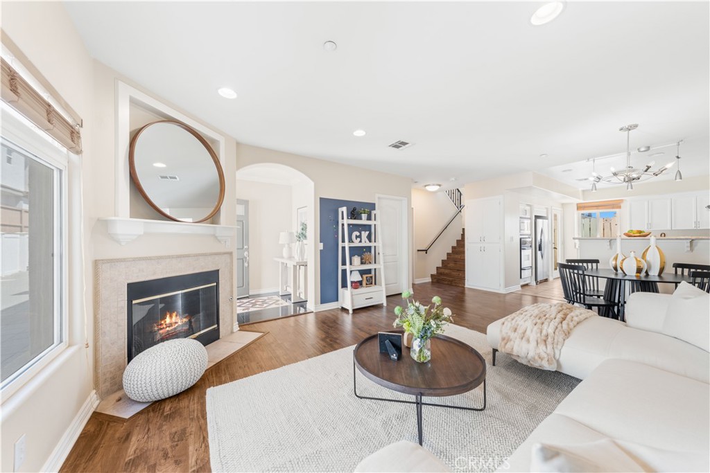 a living room with furniture a fireplace and a large mirror