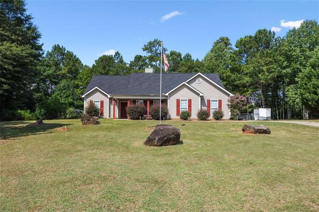 a front view of a house with a yard and trees