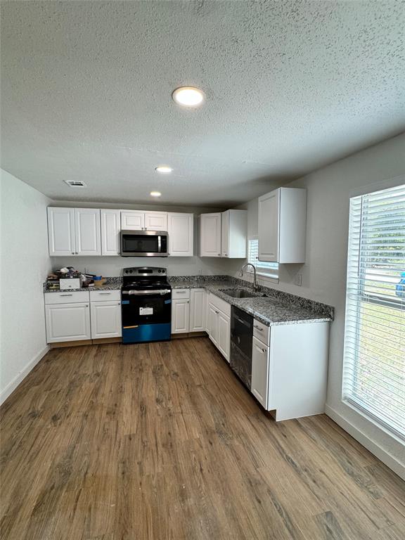 a large kitchen with a white stove top oven and white cabinets