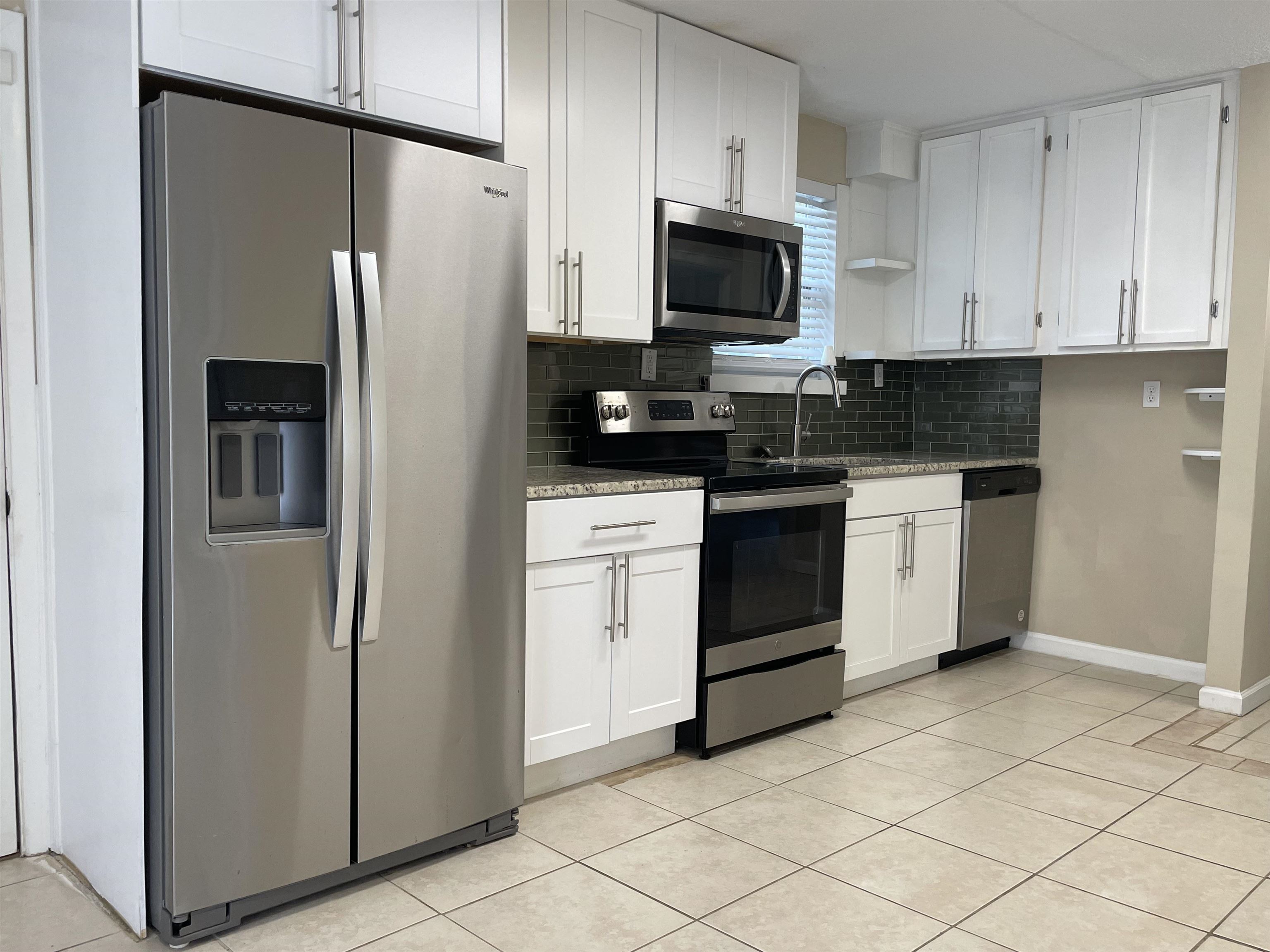 a kitchen with stainless steel appliances and white cabinets