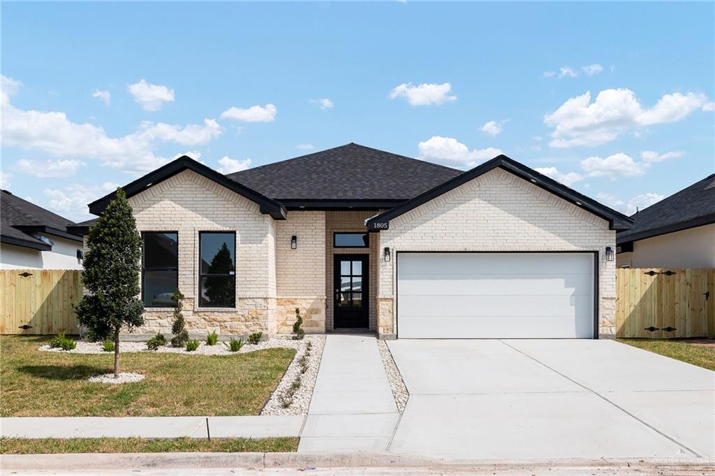 View of front facade with a front lawn and a garage