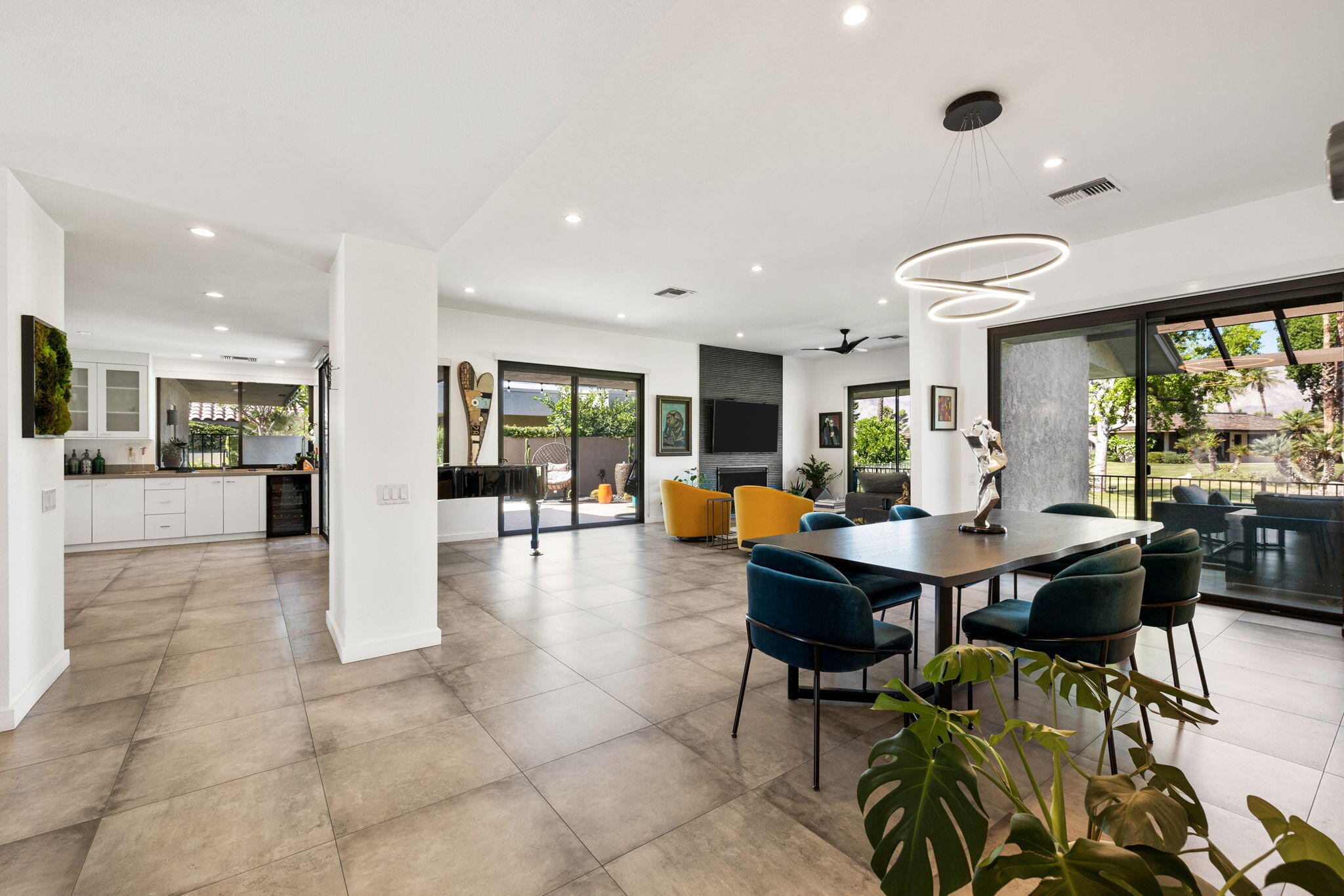 a living room with furniture a large window and kitchen view