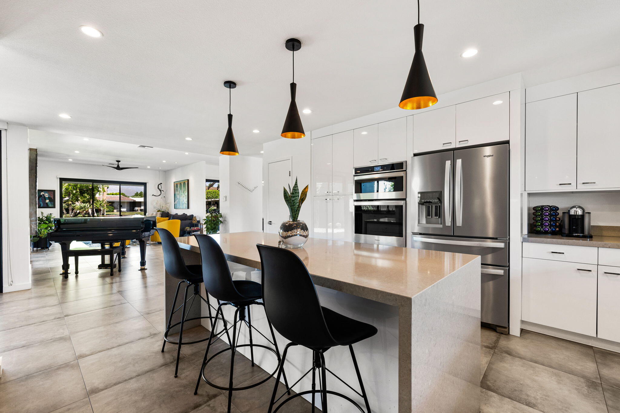 a kitchen with stainless steel appliances a dining table chairs stove and refrigerator