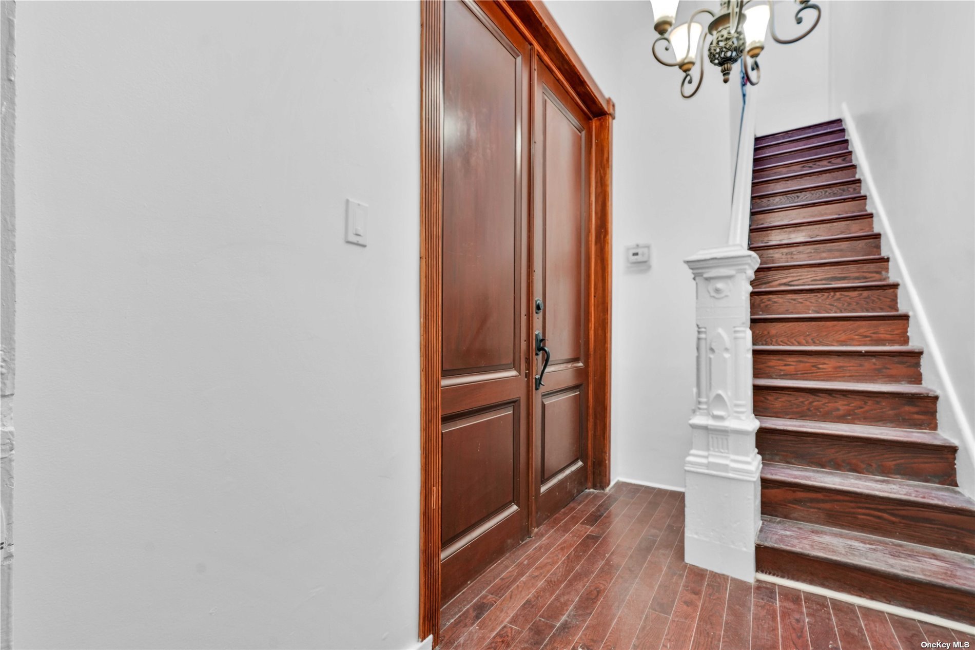 a view of a hallway with wooden floor and staircase