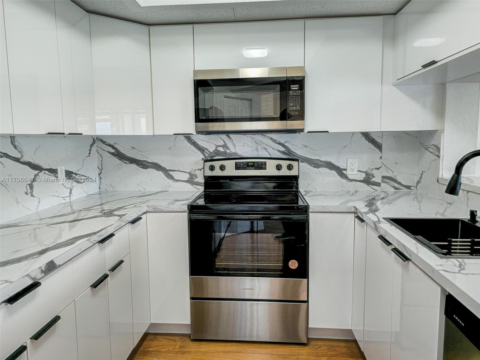 a kitchen with granite countertop a stove and a microwave