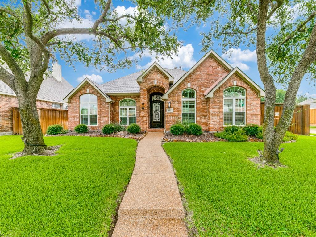 a front view of a house with a garden and yard