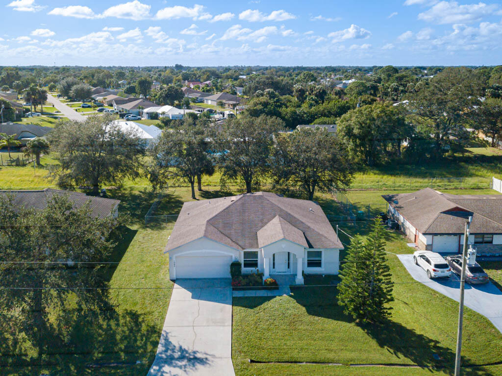 an aerial view of a house with a garden and lake view