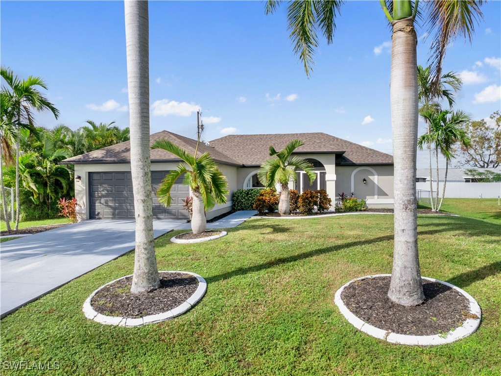 a front view of a house with a yard fountain and palm tree