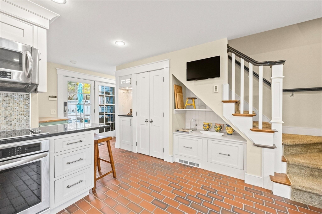 a kitchen with white cabinets and sink