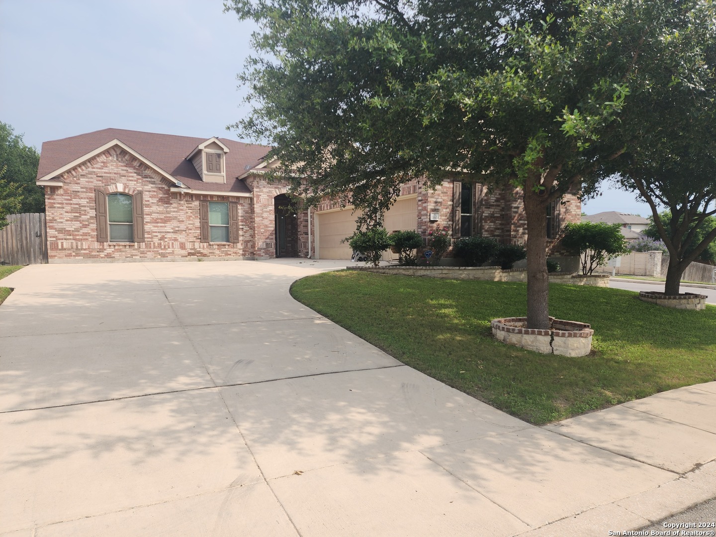 a front view of a house with a garden and trees