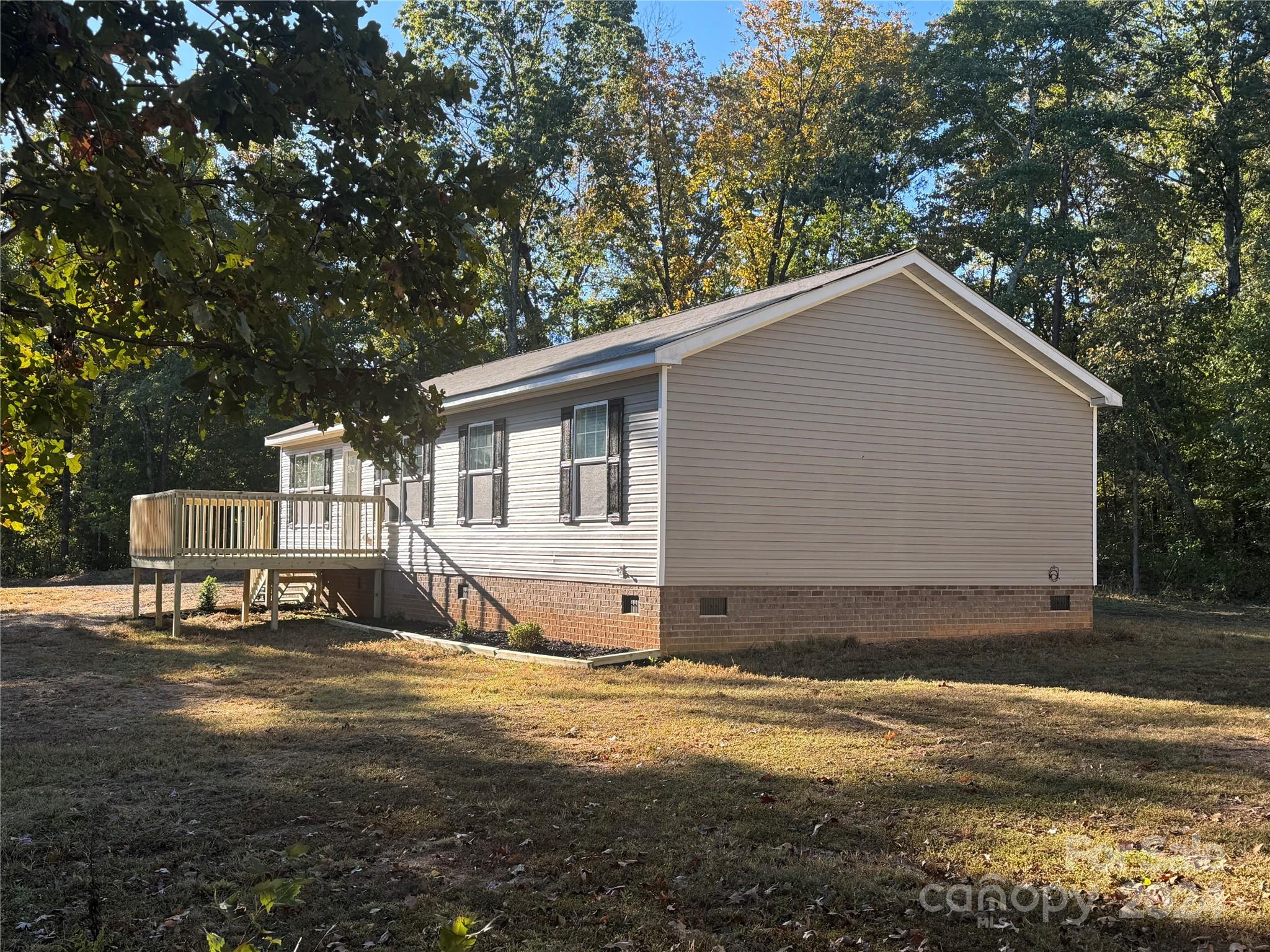 a view of a house with backyard and trees