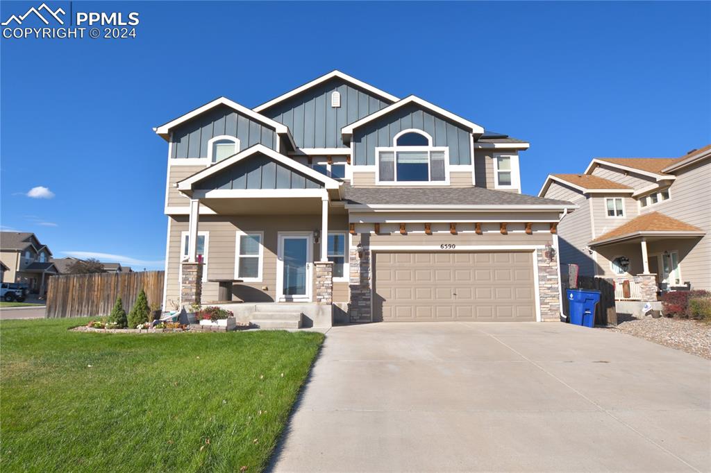 Craftsman inspired home with a front lawn and a garage