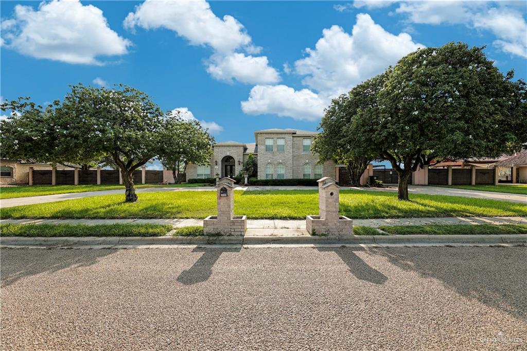 a view of a house with a big yard and a large trees