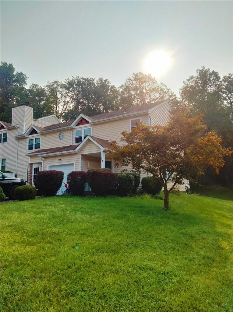 View of home's exterior with a yard and a garage