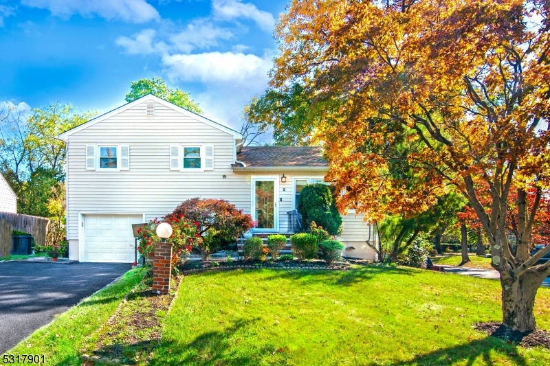 a front view of a house with a yard garage and outdoor seating