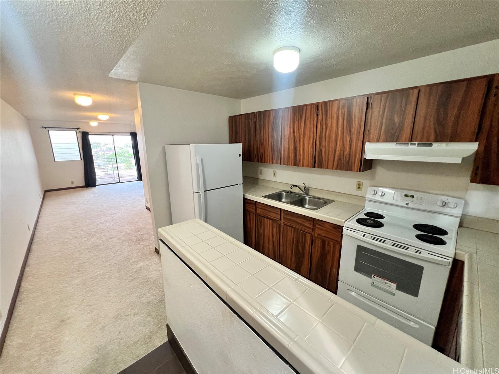 a kitchen with a white stove top oven and refrigerator