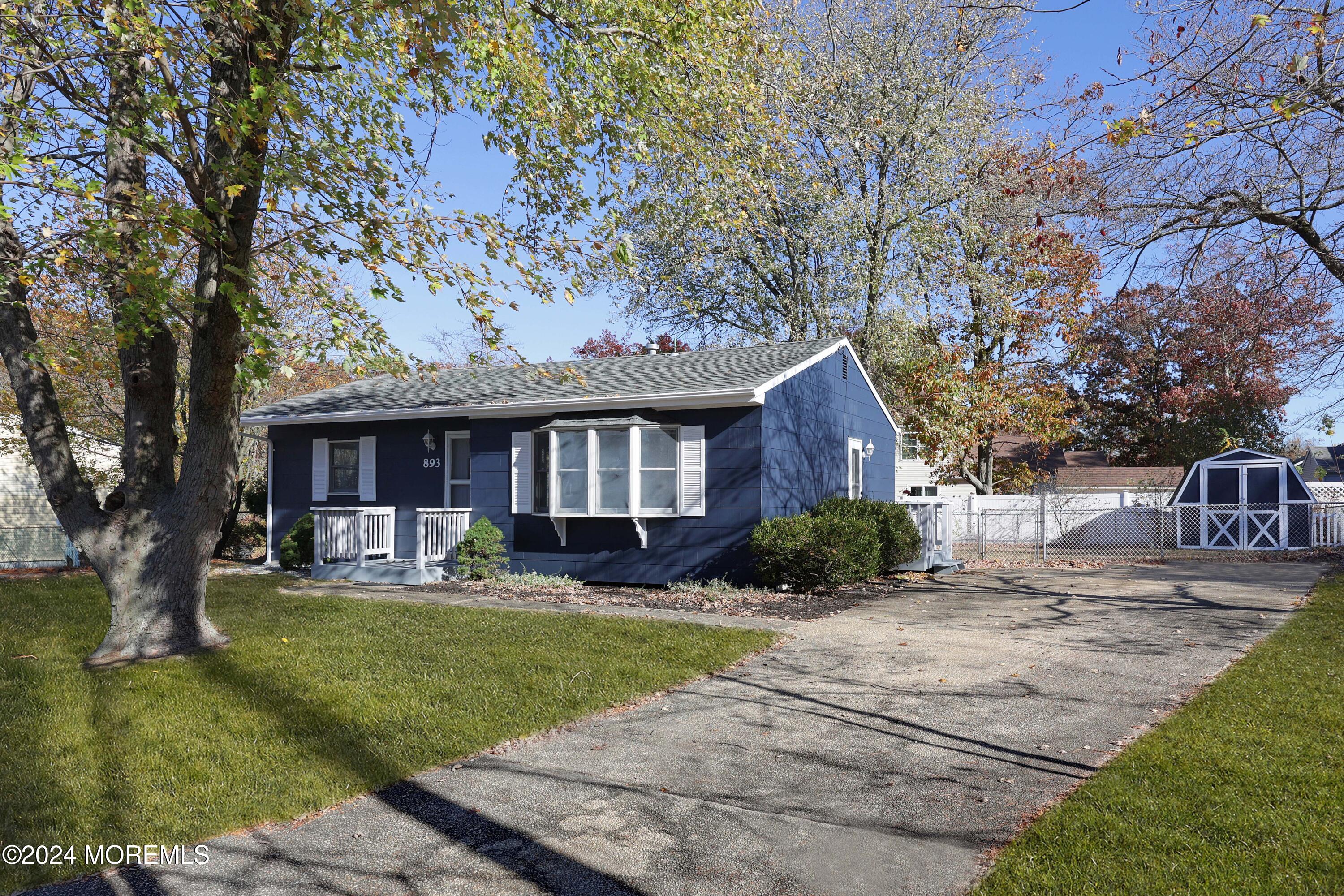 a front view of a house with a yard and trees