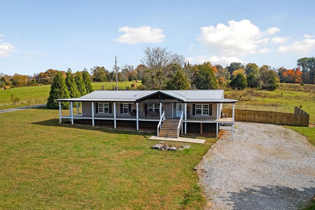 a view of a house with a yard balcony and wooden fence