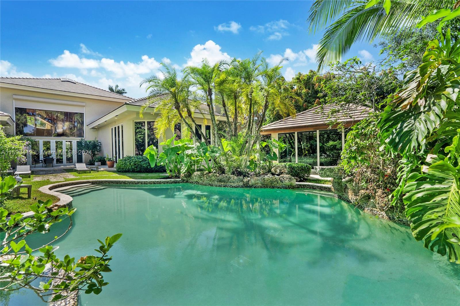 a view of a house with swimming pool lawn chairs and a yard with swimming pool