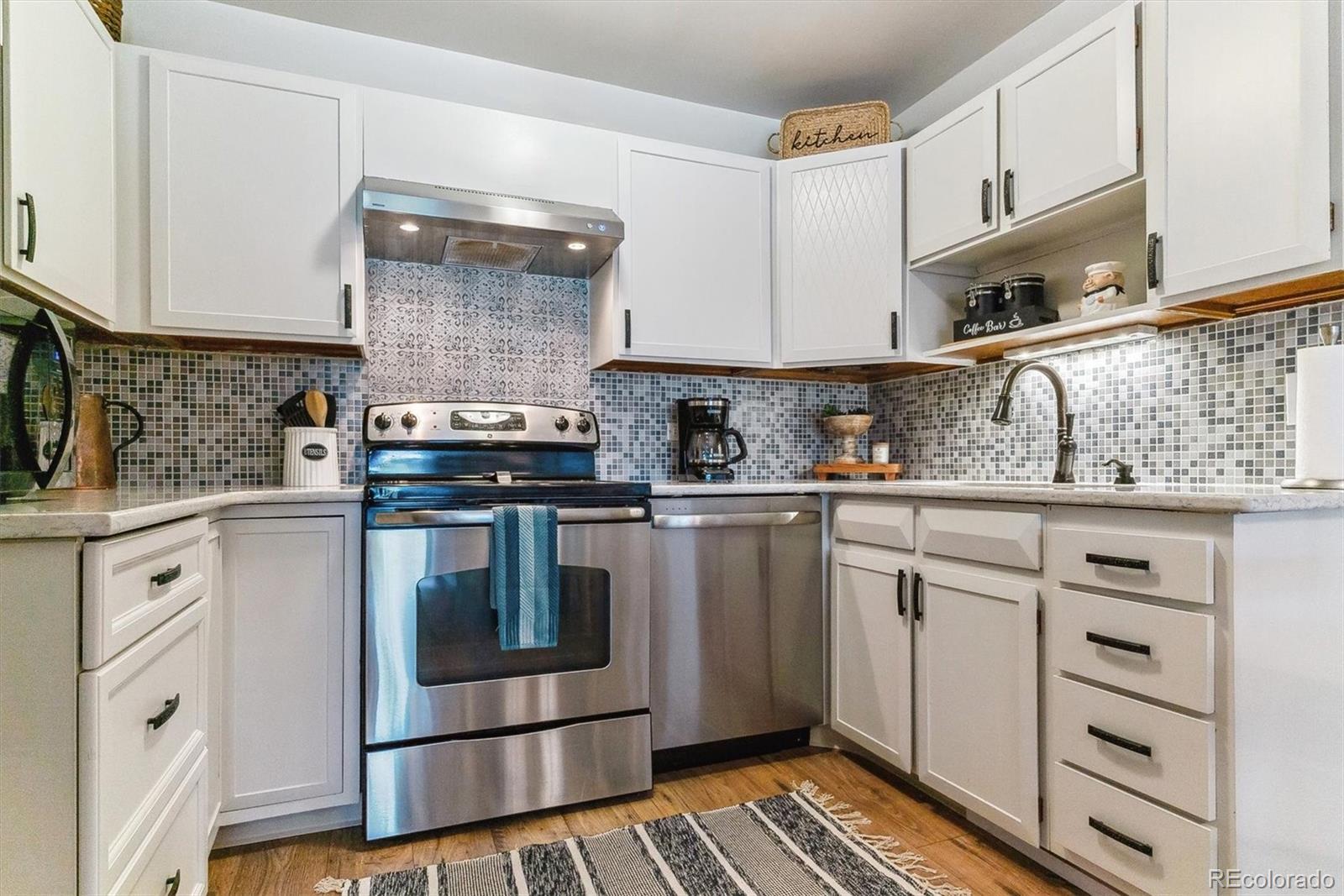 a kitchen with granite countertop a stove sink and cabinets