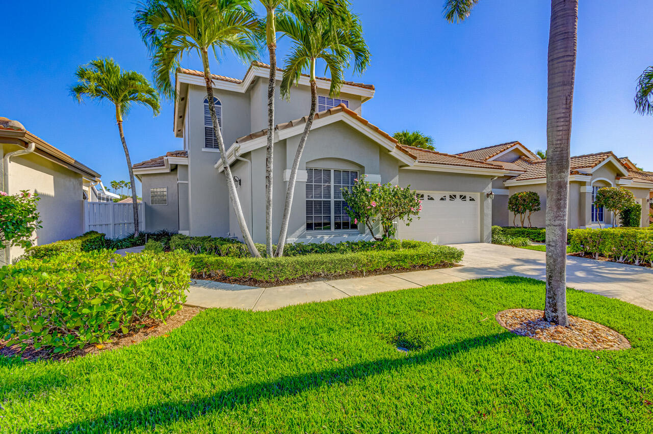 a view of a house with a big yard plants and palm trees