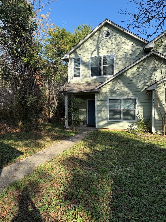 a view of a house with a yard balcony and tree