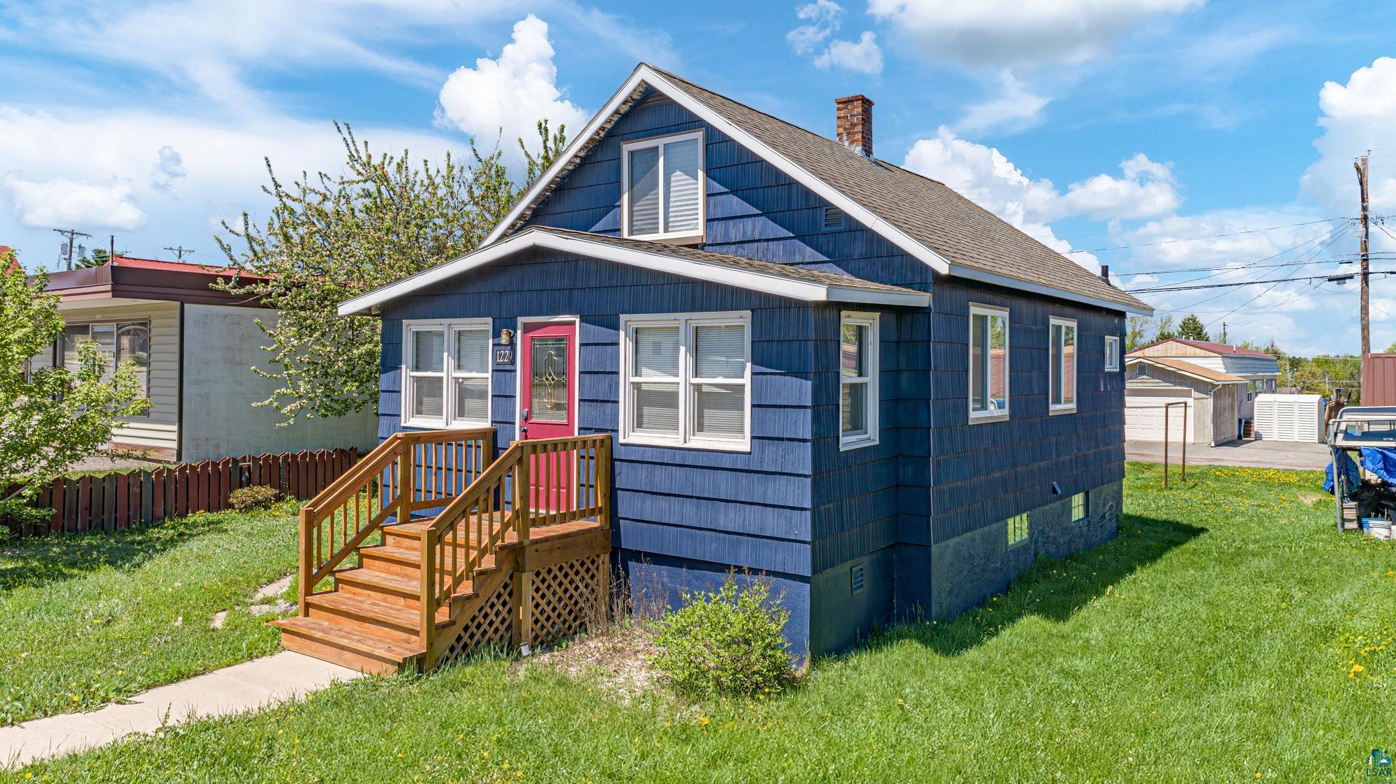 Bungalow-style house with a front lawn and an outdoor structure