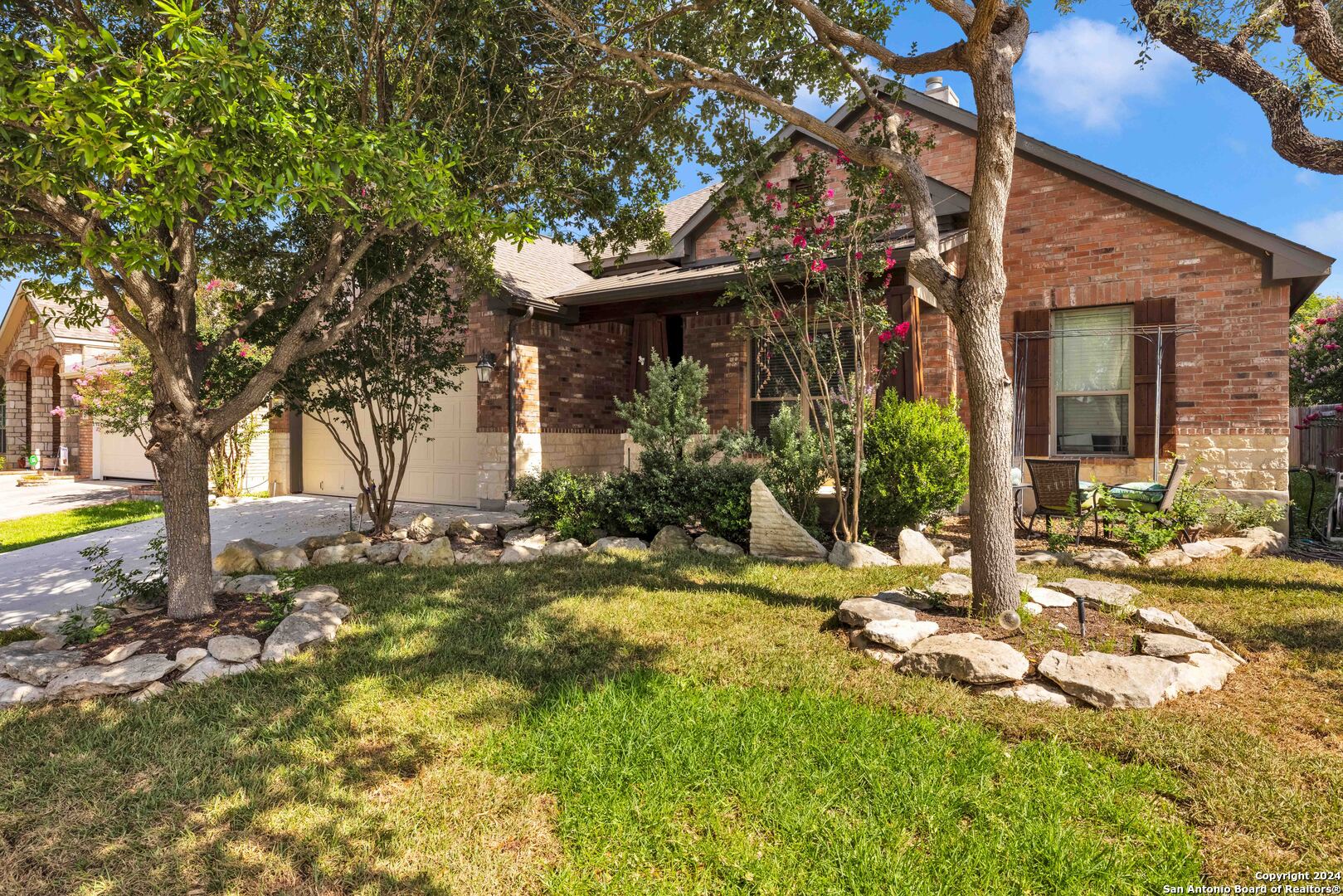 a view of a house with fountain and large tree