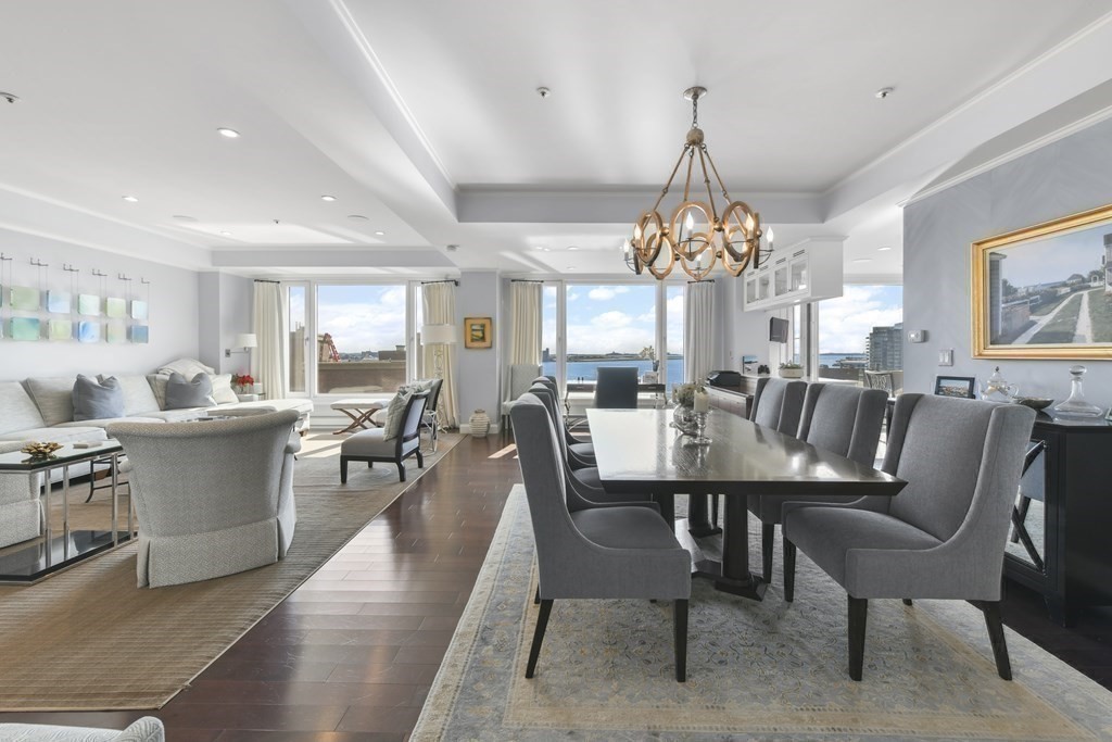 a dining room with wooden floor a chandelier a wooden table and chairs