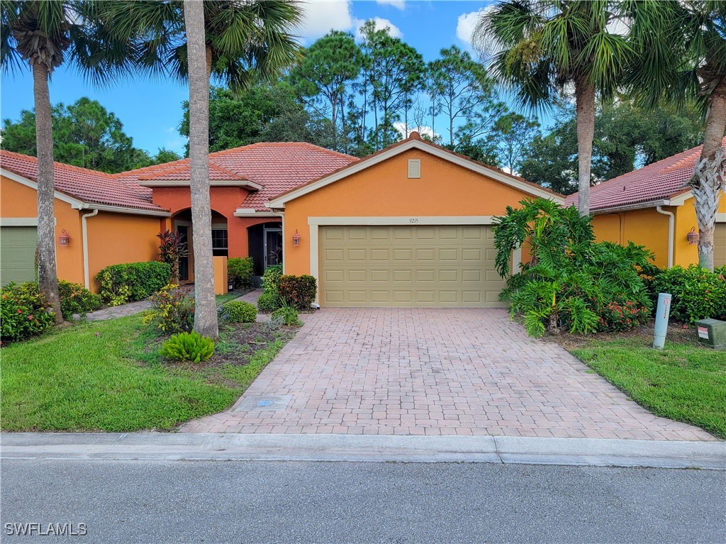 a front view of a house with a yard and a garage