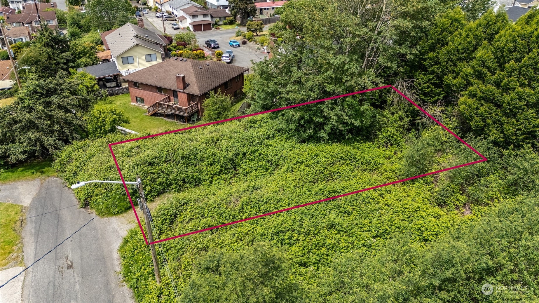 an aerial view of residential house with outdoor space and trees all around