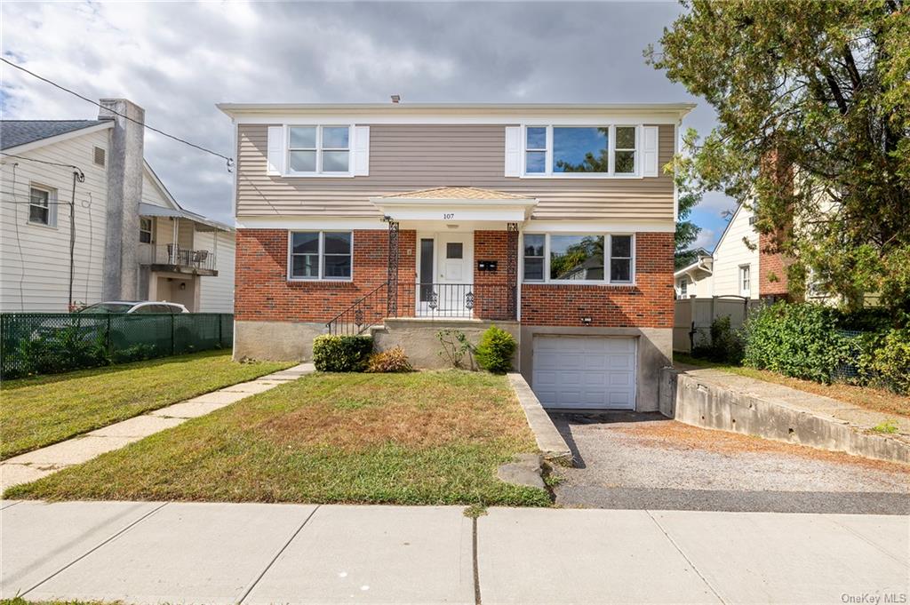 View of front of home with a front lawn and a garage