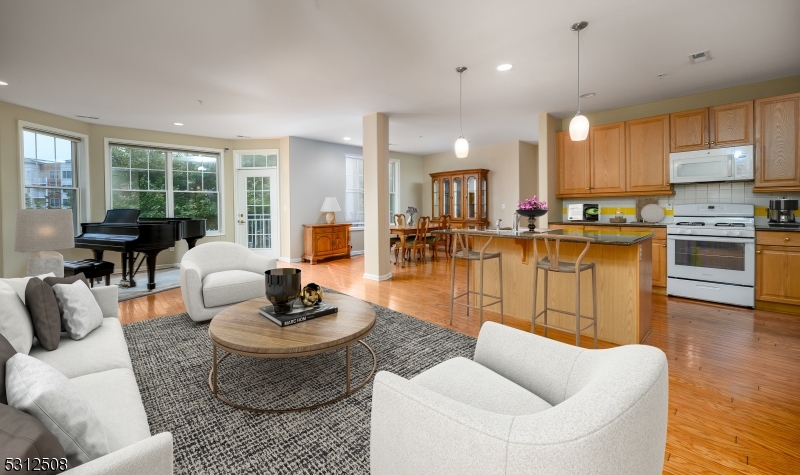 a living room with furniture kitchen view and a large window