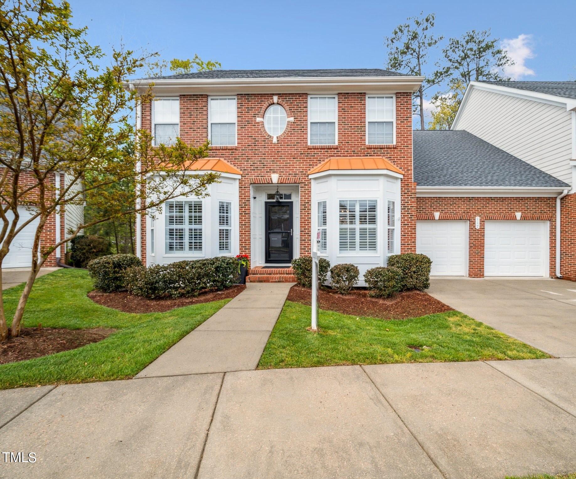 front view of a brick house with a yard