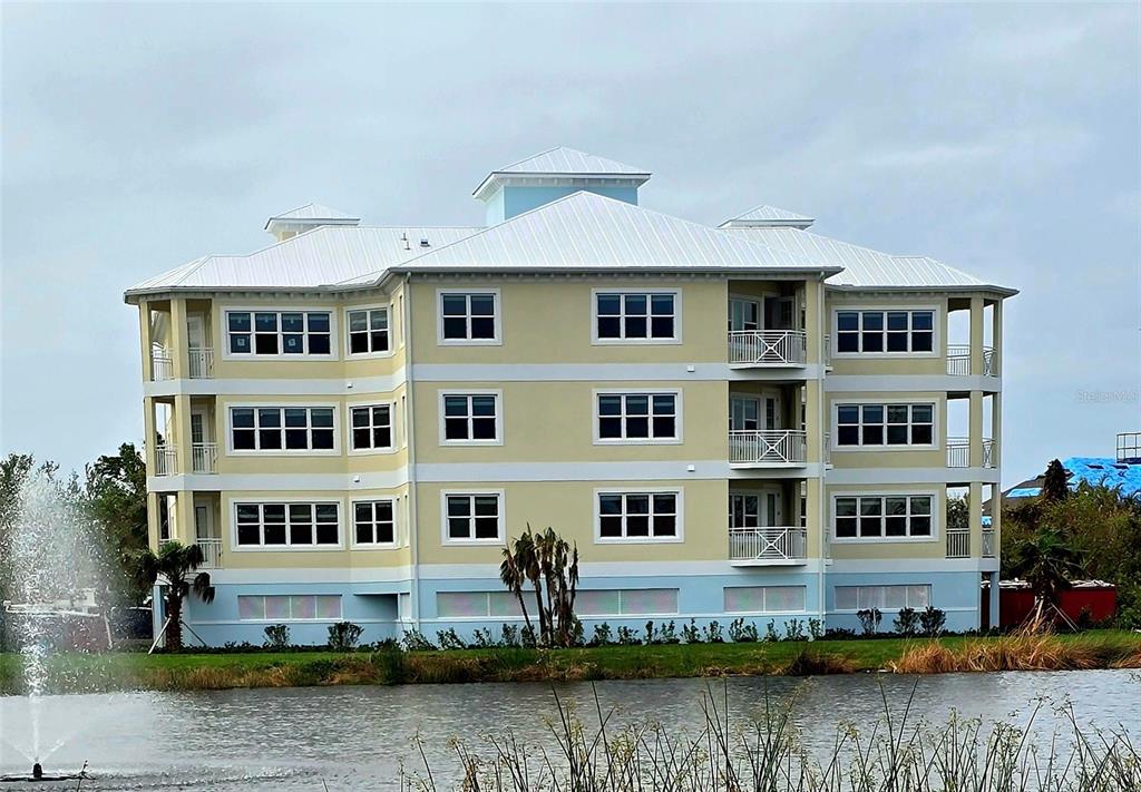 a front view of a building with lake view and houses